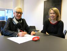 Kulturrådets direktør Anne Aasheim signerer programforslaget om kulturutveksling med Romania. EØS-rådgiver Astrid Bjerke til høyre.